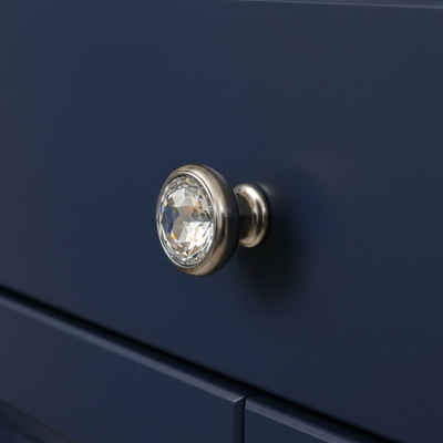 Close-up of a crystal knob on a navy blue cabinet