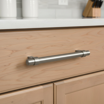Close-up of a kitchen cabinet with a metallic handle on a light wood finish.