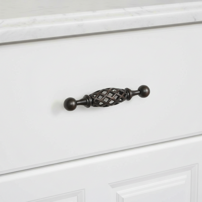 oil rubbed bronze basket style cabinet handle on a white cabinet door