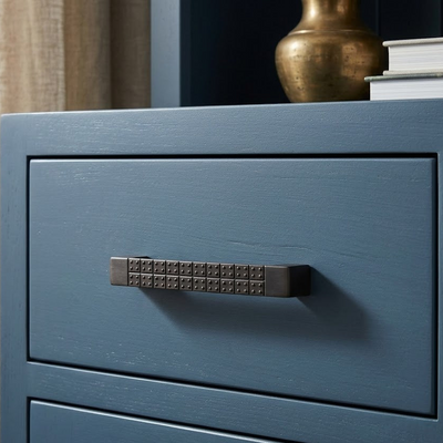 Close-up of a blue cabinet with a textured black handle