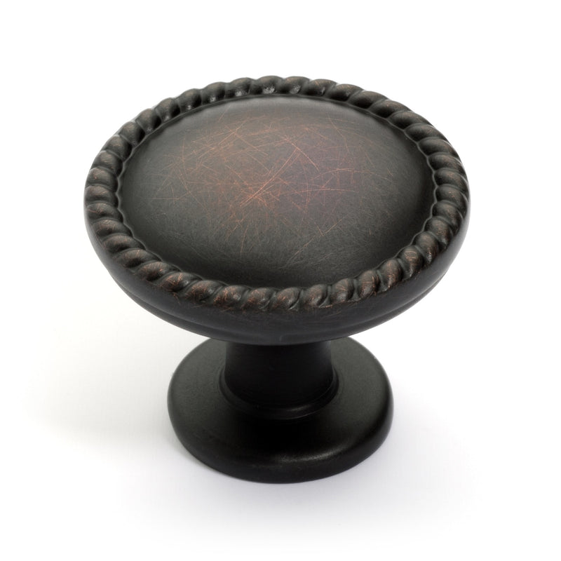 Round cabinet knob with rope design along the edges in oil rubbed bronze finish