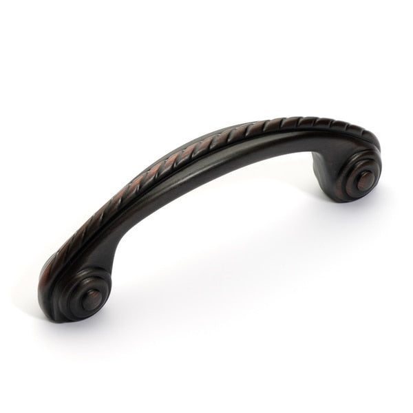 Three inch hole spacing cabinet drawer pull in oil rubbed bronze finish with rope design along the top of handle and swirl legs