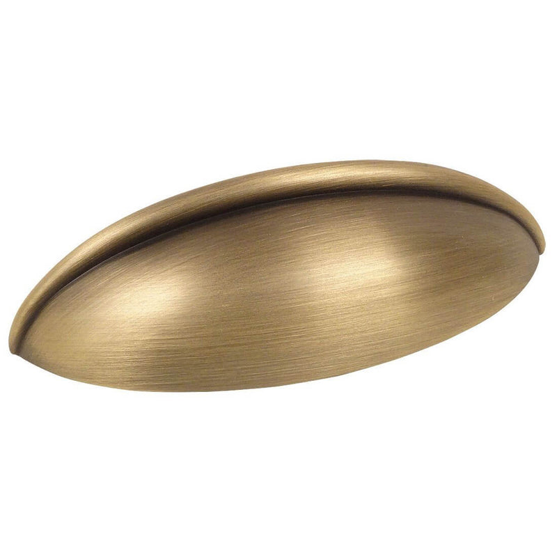 Oblong drawer pull in brushed antique brass finish with two and a half inch hole spacing. Cosmas 1399BAB cup pull in brushed antique brass. 