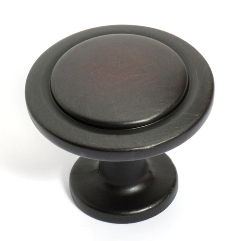 Flat cabinet knob in oil rubbed bronze finish with slightly raised center 