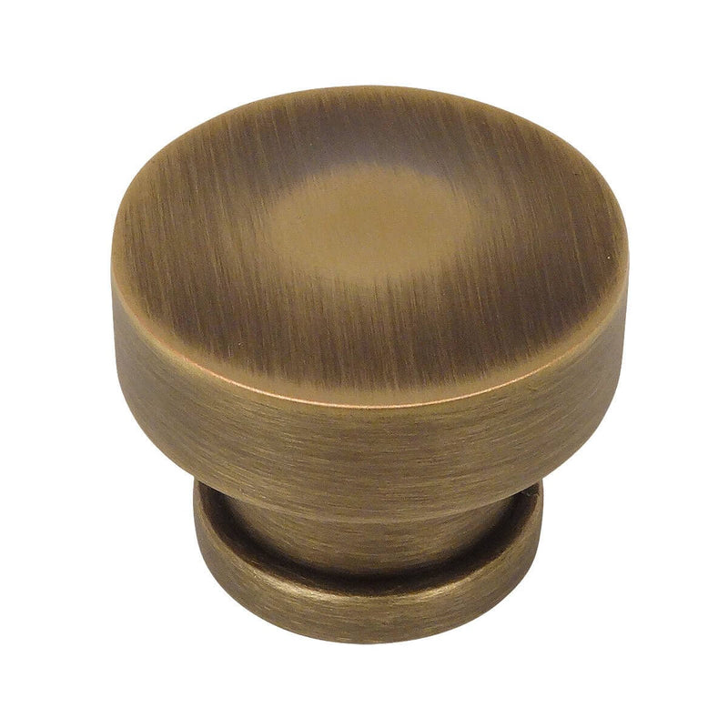 Round rigid cabinet knob in brushed antique brass finish with one and a quarter inch diameter