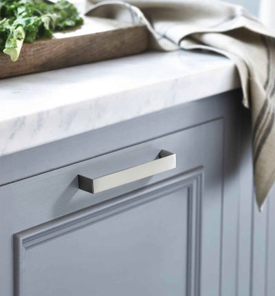 Contemporary silver cabinet pull on slate blue bathroom cabinet with white granite countertop