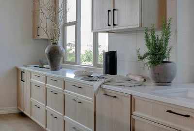 light wood cabinets with long black modern pulls