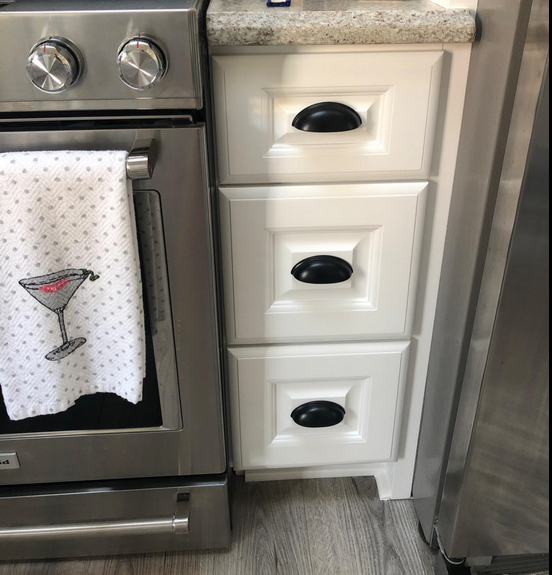 Cosmas 1399FB Flat Black Cabinet Cup Pull on white shaker drawers. The 2-1/2 inch hole centers cup pull perfectly sits on the raised piece of the shaker. 