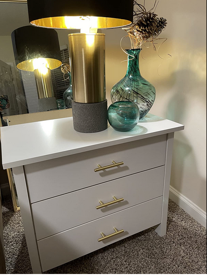 Cosmas 305-2.5BB Brushed Brass Euro Style Bar Pull on a white nightstand