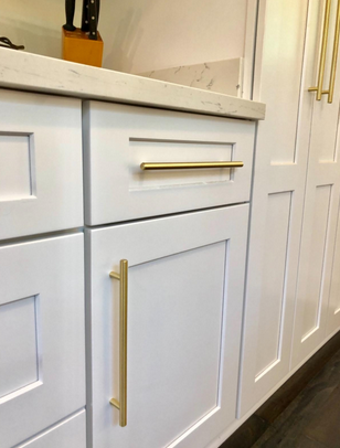 Cosmas 305-224BB Brushed Brass Euro Style Bar Pull on white cabinets and white pantry 