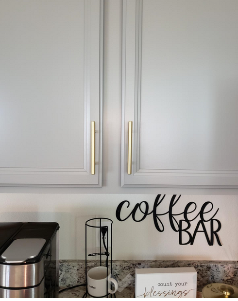 Cosmas 305-96BB Brushed Brass Euro Style Bar Pull on light gray kitchen cabinets