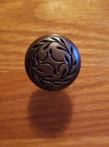 Cosmas 464ORB Oil Rubbed Bronze Cabinet Knob close up on light oak cabinet