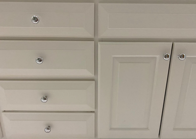 Round cabinet knobs on soft white bathroom vanity featuring the Cosmas 4950CH Polished Chrome Cabinet Knob