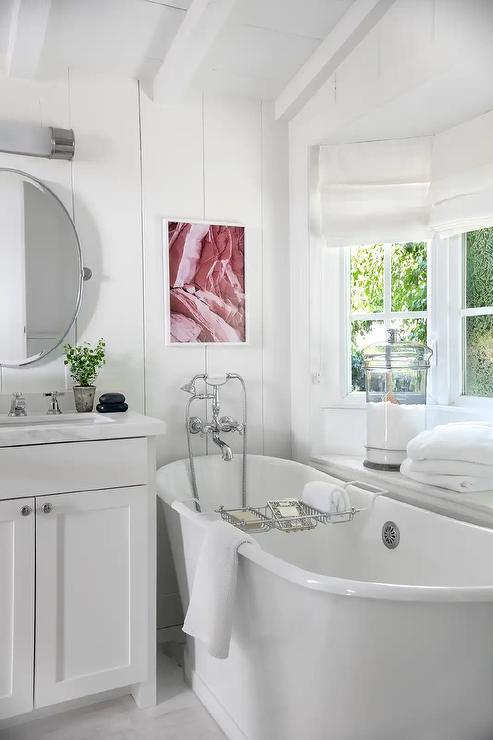 Gorgeous white bathroom with soaking tub and a vanity with the round cabinet knob by Cosmas 4950SN in satin nickel finish. 