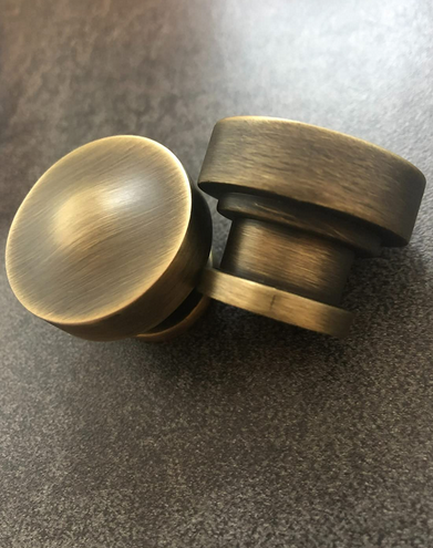 close up of two round brushed antique brasss solid metal cabinet knobs by Cosmas 704BAB