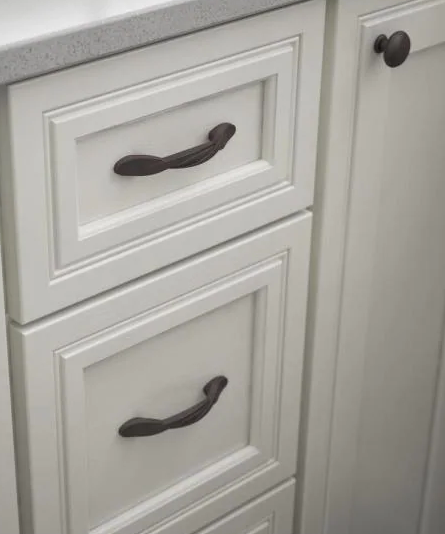 A white bathroom vanity with three drawers and one cabinet door. The drawers have a twist cabinet pull in an oil rubbed bronze finish. The cabinet door features a round knob also in the oil rubbed bronze finish. 