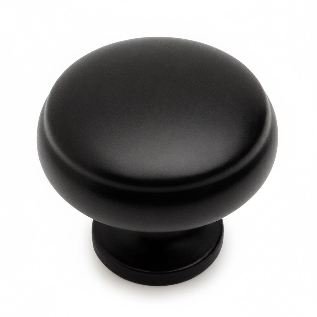 Round flat black cabinet knob with subtle beveled lip design and one and three sixteenths inch diameter