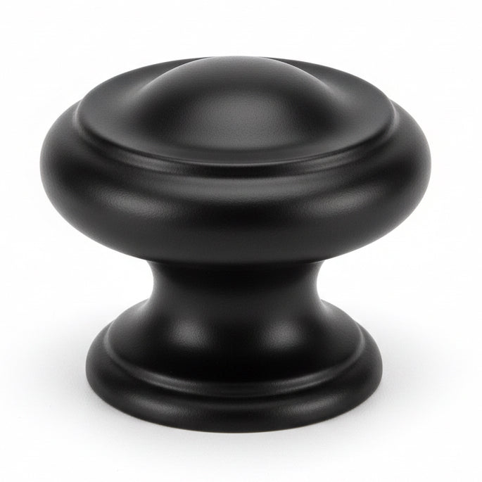Round cabinet knob in flat black finish with slightly raised ring and one and three sixteenths diameter