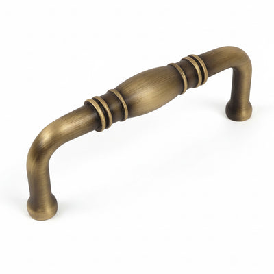 Cabinet pull with brushed antique brass finish with a bulge at the centre and three inch hole spacing