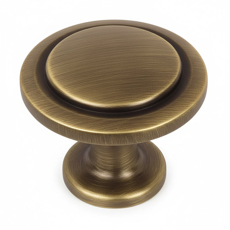 Round drawer knob in brushed antique brass finish with circle craving and one and a quarter inch diameter