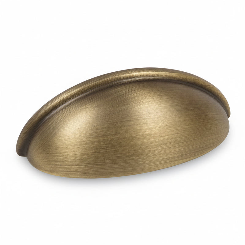 Cabinet cup pull in brushed antique brass finish with three inch hole spacing