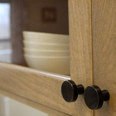 oil rubbed bronze cabinet knobs in a wood kitchen 

