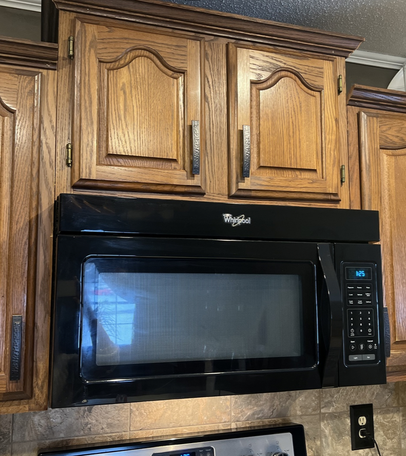 Upper cabinets in an oak wood finish kitchen cabinets with the craftsman hammered cabinet pulls and cup pulls. The pulls featured are Cosmas 10557ORB Oil Rubbed Bronze Zinc Cabinet Pulls